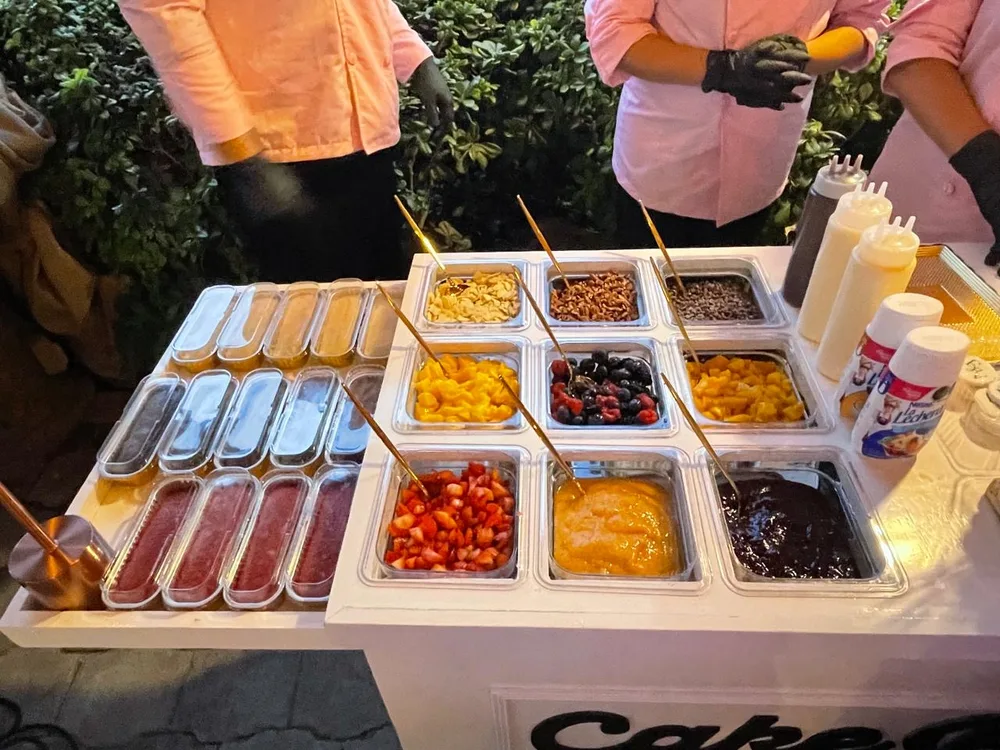 Barra de toppings del Cake Bar con frutas, mermeladas y dulces