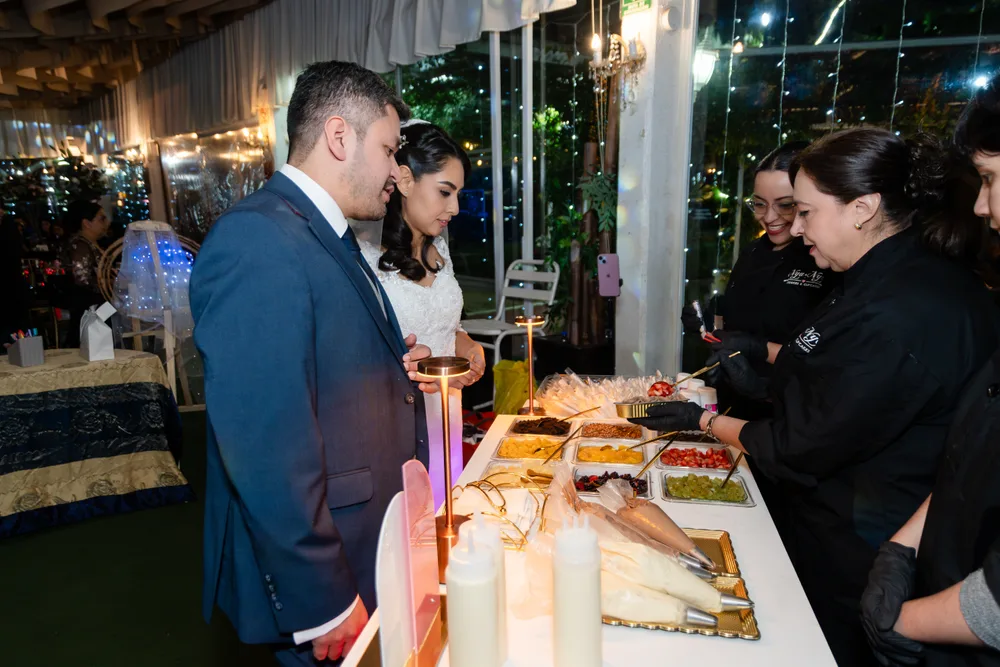 Invitados armando su pastelito en el Cake Bar durante una boda